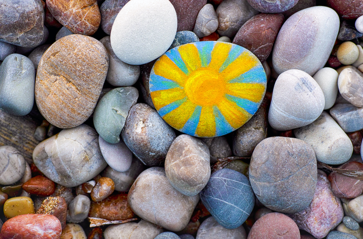 Bright sun painted on pebble.